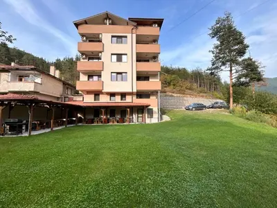 a building with a large lawn in front of it at Къща за гости Кристияна in Devin