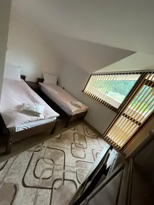 a small room with two beds and a window at Къща за гости Кристияна in Devin