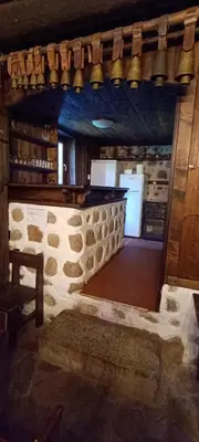 a kitchen with a stone wall and a refrigerator at Къща за гости- Шале Мила in Bansko