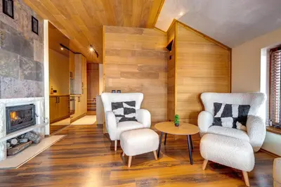 a living room with two chairs and a fireplace at Luxury 1BD Retreat in Grand Resort Pamporovo by Flat Manаger in Pamporovo