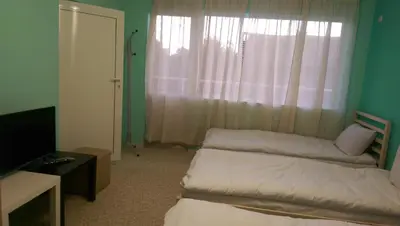 a small room with two beds and a window at Стаи за гости Деметра in Sofia