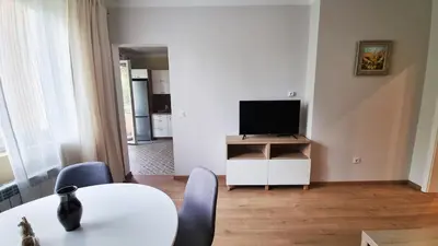 a living room with a table and a television at No X - Sofia top center in Sofia