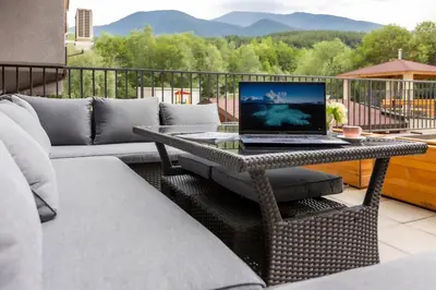 a laptop computer sitting on a table on a patio at Incredible 2BDR with Veranda and House-like Feel in Bansko