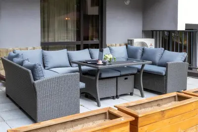 a patio with a couch and a table and chairs at Incredible 2BDR with Veranda and House-like Feel in Bansko