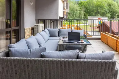 a couch sitting on a patio with a laptop on it at Incredible 2BDR with Veranda and House-like Feel in Bansko