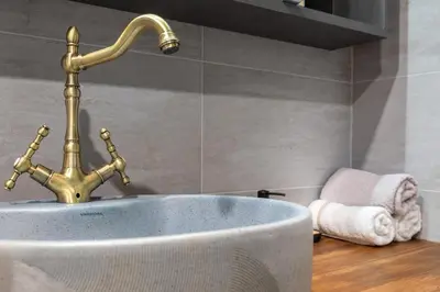 a sink with a gold faucet in a bathroom at Incredible 2BDR with Veranda and House-like Feel in Bansko