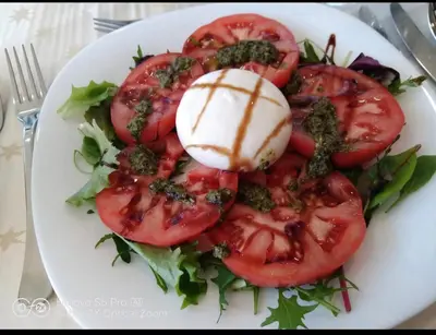 a plate of food with tomatoes and cheese on it at Stay with Me Women only room parking childrens pets welcom in Sofia
