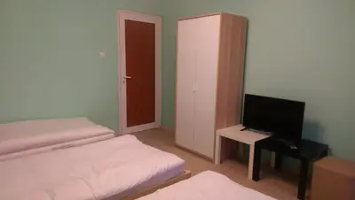a small room with two beds and a television at Стаи за гости Деметра in Sofia