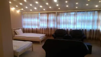 a room with two chairs and a window with lights at Стаи за гости Деметра in Sofia