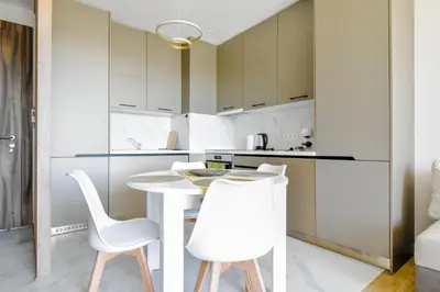 a kitchen with a white table and white chairs at Modern 1BD Near Paradise Center & Vitosha Metro by Flat Manager in Sofia
