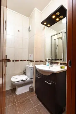 a bathroom with a toilet and a sink and a mirror at Modern 2BD - 14 min to Medical University by Flat Manager in Plovdiv