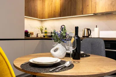 a wooden table with a plate and a bottle of wine at Two Stylish 1BD Apartments with Desk in Karshiaka by Flat Manager in Plovdiv