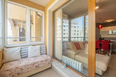 a balcony with a couch in a room with windows at Modern Apartment - Top Location - Friendly Host by Flat Manager in Sofia