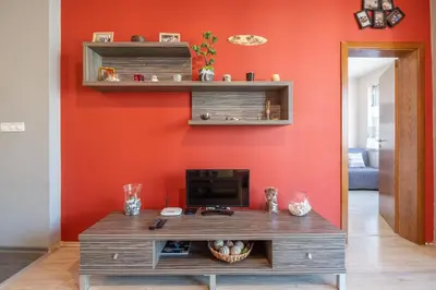 a living room with an orange wall with a desk at Modern Apartment - Top Location - Friendly Host by Flat Manager in Sofia