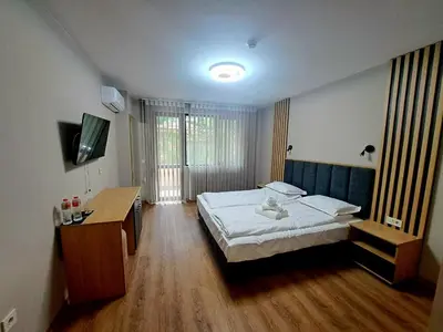 a bedroom with a bed and a desk and a television at Хотел Ресторант Ваката in Teteven