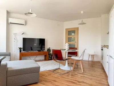 a living room with a couch and a table at 1BR Apartment with a Designated Workspace, Free Street Parking and Free Gym Pass in Plovdiv