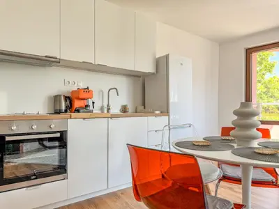 a kitchen with white cabinets and a table at 1BR Apartment with a Designated Workspace, Free Street Parking and Free Gym Pass in Plovdiv