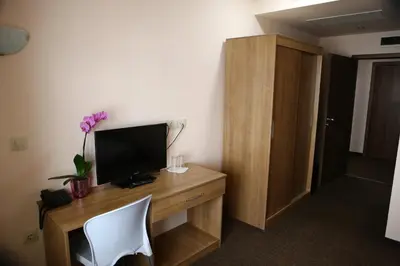 a room with a desk with a television and a chair at Hotel Iris in Plovdiv
