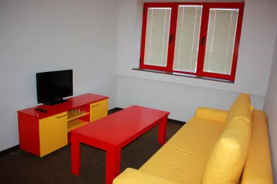 a living room with a couch and a table and a tv at Hotel Iris in Plovdiv