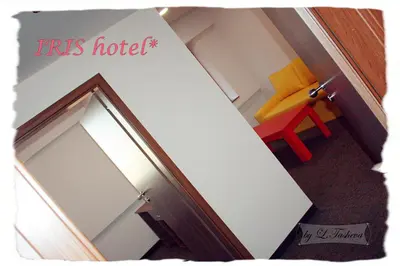 a mirror in front of a room with a chair at Hotel Iris in Plovdiv