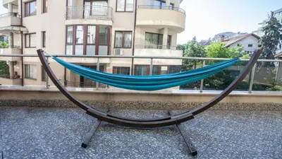 a blue hammock sitting in front of a building at City Nest 1BD in Lozenets by Flat Mаnager in Sofia