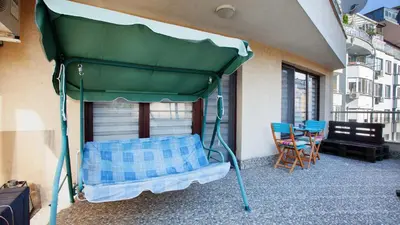 a green canopy bed on a balcony with a table at City Nest 1BD in Lozenets by Flat Mаnager in Sofia