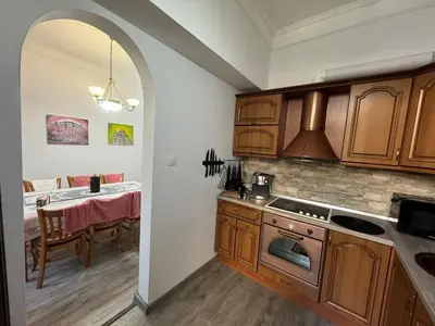 a kitchen with wooden cabinets and a dining room with a table at Retro Gem in Sofia