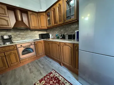 a kitchen with wooden cabinets and a white refrigerator at Retro Gem in Sofia