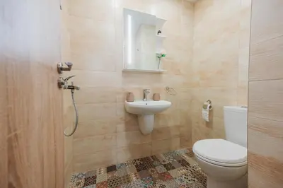 a bathroom with a toilet and a sink at Pavlina Guest House in Tsŭrvishte