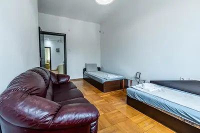 a living room with a leather couch and a bed at Sofique 3BR in Sofia