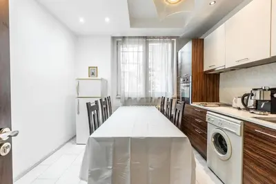a kitchen with a table and chairs in it at Sofique 3BR in Sofia