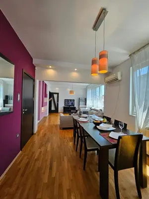 a dining room and living room with a table and chairs at Simply The Best - Vitosha blvd in Sofia
