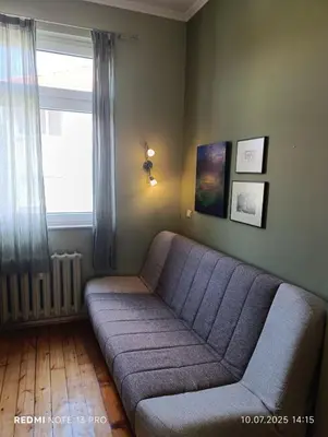 a living room with a couch and a window at Vinchenco and G Suites in Sofia