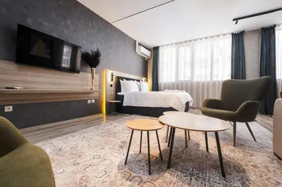a hotel room with a bed and a table and chairs at А17 Plovdiv Apartments - Next to Rowing Channel and University hospitals in Plovdiv