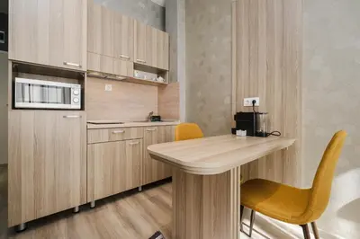 a kitchen with wooden cabinets and a table and chairs at А17 Plovdiv Apartments - Next to Rowing Channel and University hospitals in Plovdiv