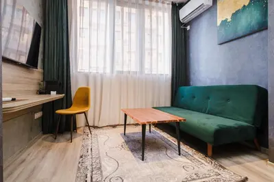 a living room with a green couch and a table at А17 Plovdiv Apartments - Next to Rowing Channel and University hospitals in Plovdiv