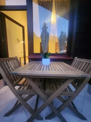 a wooden table with a potted plant on a porch at Borovets Violet by Ski slopes in Borovets