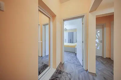 a hallway with a mirror and a bedroom at Oranssi Sunset - Free Parking in Sofia