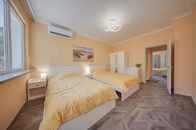a bedroom with two beds and a ceiling fan at Oranssi Sunset - Free Parking in Sofia