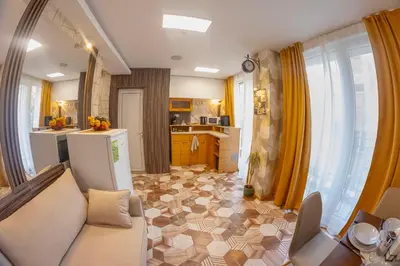 a living room with a couch and a kitchen at Good Mood Apartments & Parking in Plovdiv