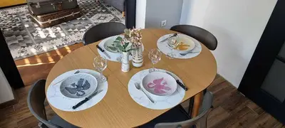 a wooden table with plates and wine glasses on it at Appartement vintage près de l'Académie de Medecine in Sofia