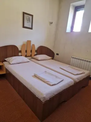 a bedroom with two beds with towels on them at Семеен хотел МАКСИМ in Teteven