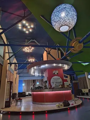 a lobby with a red couch and a chandelier at Семеен хотел МАКСИМ in Teteven