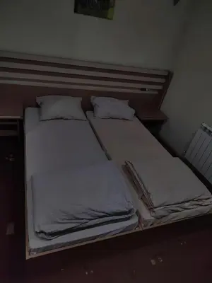 two twin beds in a small room with at Семеен хотел МАКСИМ in Teteven