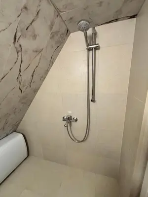 a shower in a bathroom with a marble wall at Studio with TERRACE - city center in Plovdiv