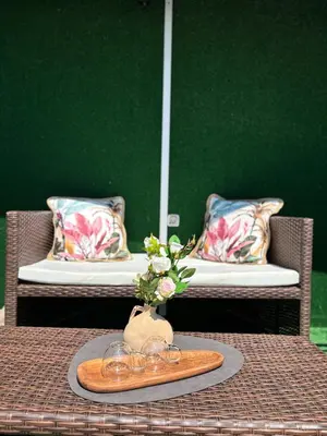 a table with a tray with glasses and a vase with flowers at Studio with TERRACE - city center in Plovdiv