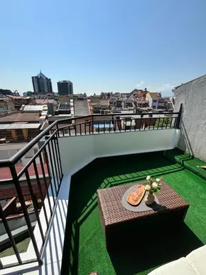 a balcony with a table with a pizza on it at Studio with TERRACE - city center in Plovdiv