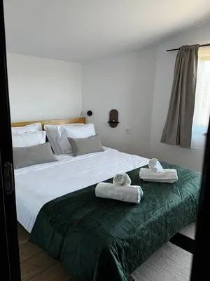 a bedroom with a large bed with towels on it at Уютни планински апартаменти с басейн в комплекс Алпин Лодж in Bansko