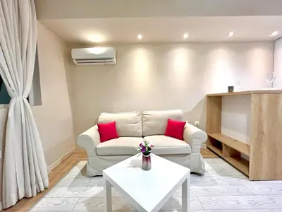 a living room with a couch and a table at Winter Palace Vitosha View Studio in Sofia