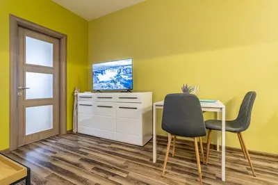 a yellow room with a desk and two chairs at Ishirkov Residence One Bedroom Apartment in Sofia